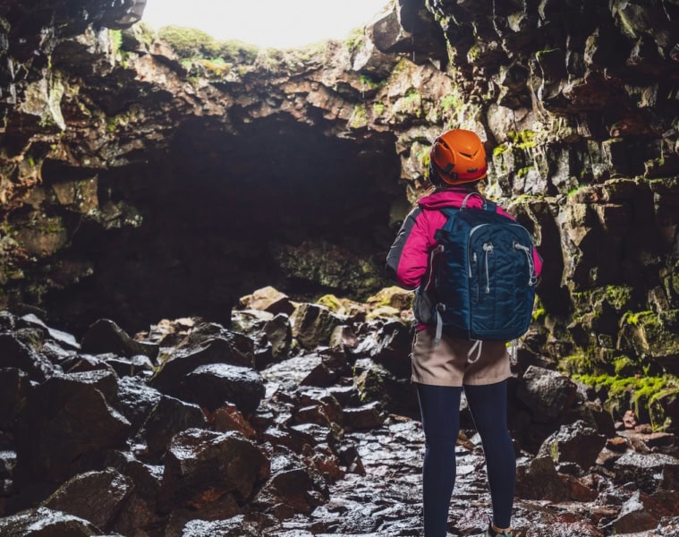 Frau steht am Eingang einer Höhle in Deutchalnd