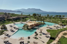 Poolanlage des Resorts Ikos Kissamos auf Kreta, im HIntergrund das Meer und die Berge.