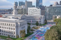 Ein halbrundes, weißes, klassizistisches Gebäude mit einem zentralen Turm: das City and County Building in Denver. Die gesamte Straße davor ist bunt bemalt.