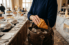 Hand lässt Croissant in Handtasche am Hotel-Frühstücksbuffet verschwinden
