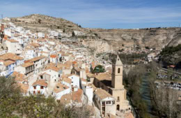 Panoramablick auf das historische Dorf Alcalá del Júcar mit seinen weißen Häusern, der Kirche und den Felsen in Kastilien-La Mancha, Spanien.