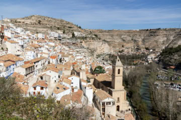Panoramablick auf das historische Dorf Alcalá del Júcar mit seinen weißen Häusern, der Kirche und den Felsen in Kastilien-La Mancha, Spanien.