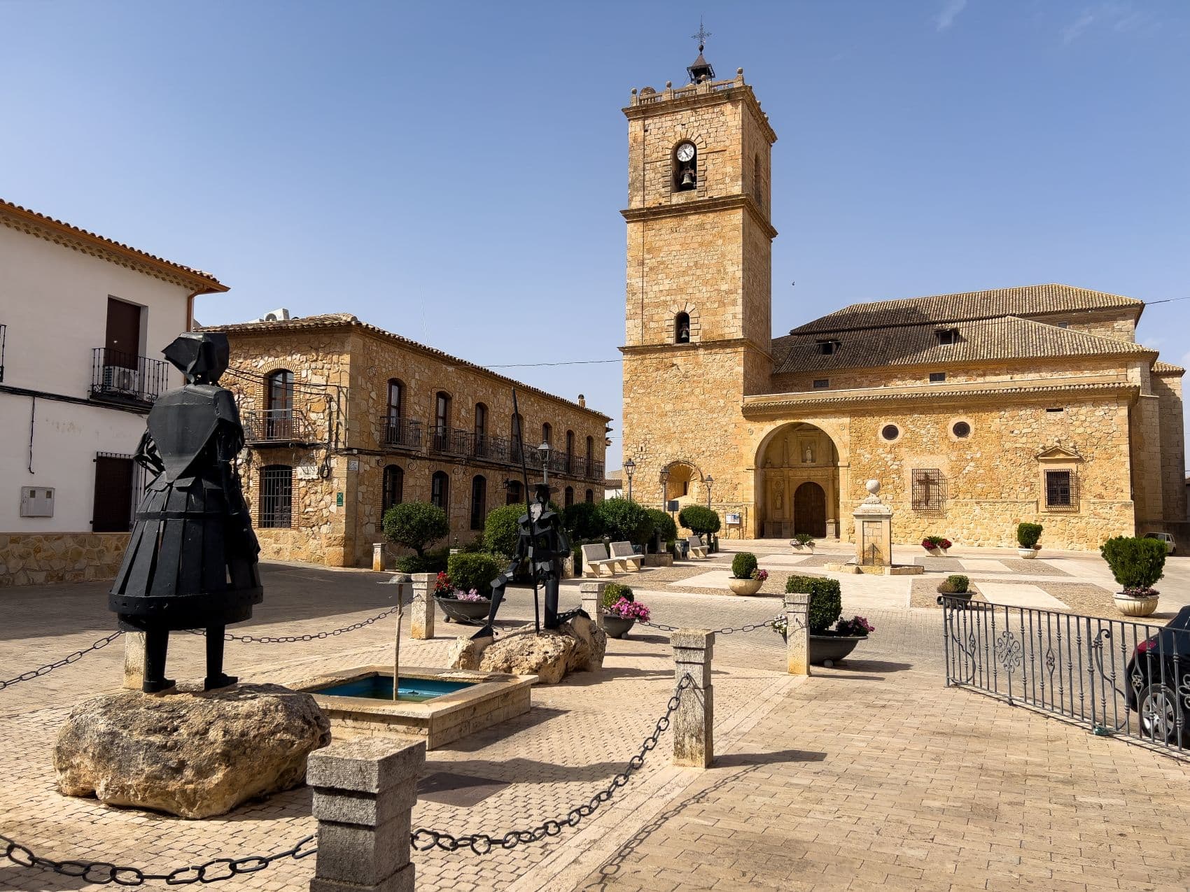 Der Dorfplatz von El Toboso mit der Pfarrkirche San Antonio Abad und Don-Quijote-Skulpturen in Kastilien-La Mancha, Spanien.