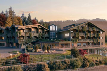 Aussenansicht des Hotel Aui in Meransen bei Sonnenuntergang mit moderner Chalet-Architektur und Holzfassade