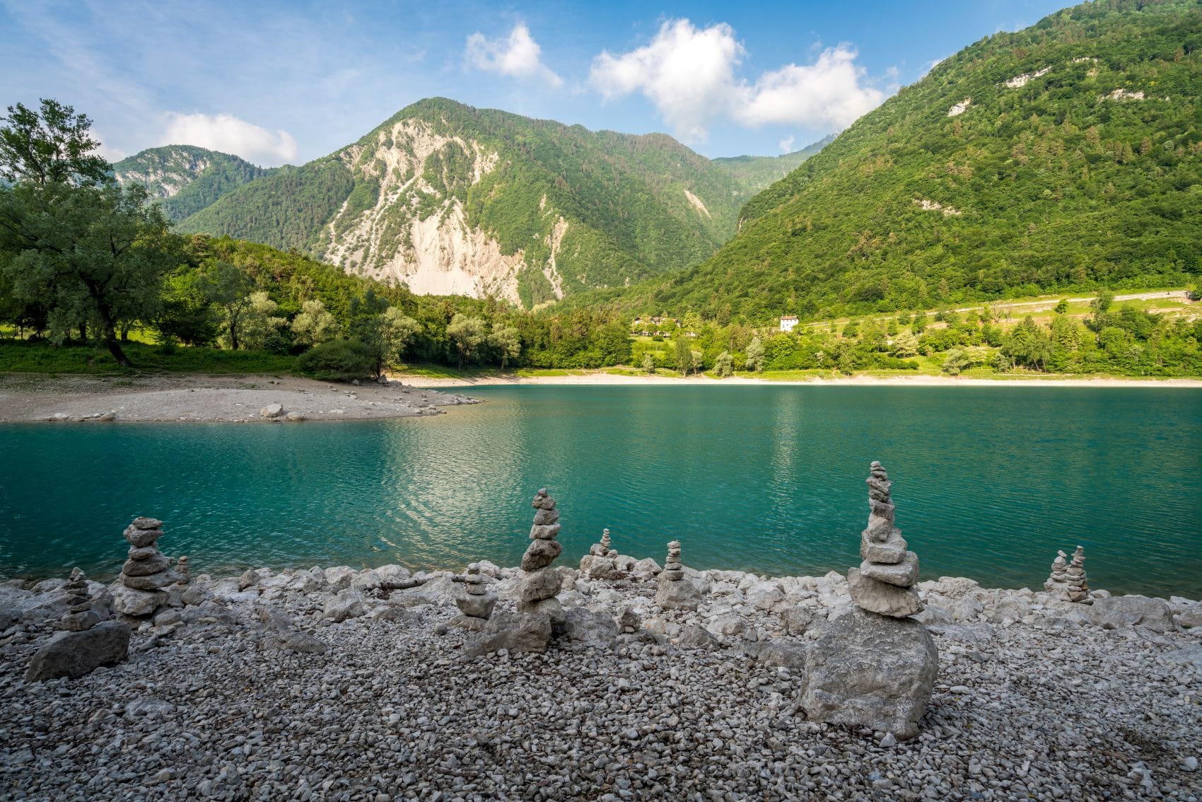 Der türkisblaue Lago di Tenno im Trentino vor einer Bergkulisse