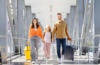 Familie mit Rollkoffern auf dem Weg zum Abflug im Flughafen-Terminal