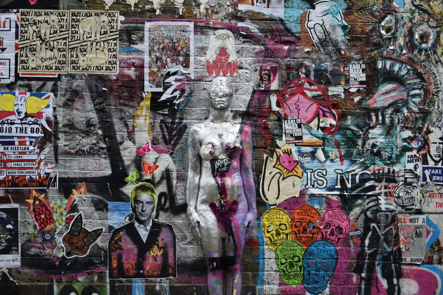 Mit Postern und Aufklebern bedeckte Wand in Shoreditch, London