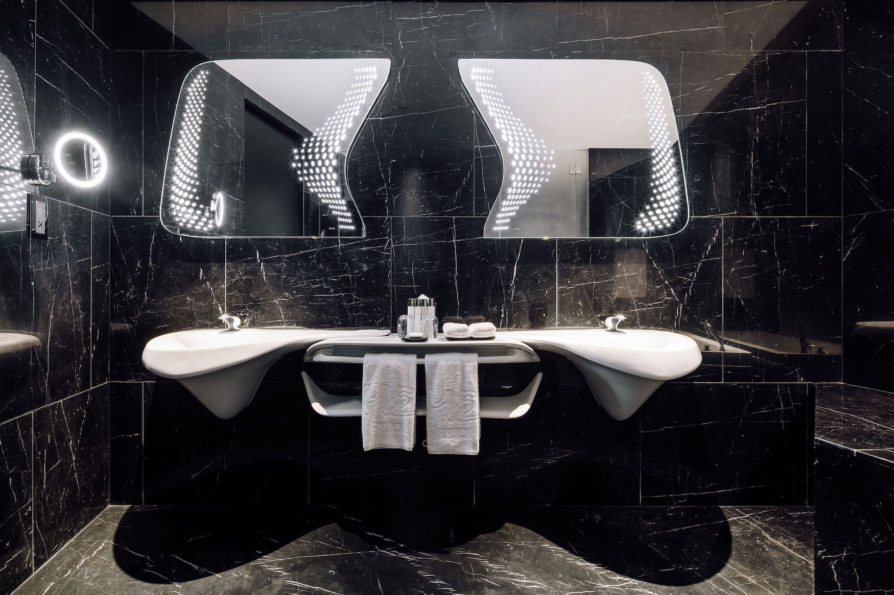 Badezimmer im ME Dubai by Meliá mit schwarzem Marmor und geschwungenen Waschbecken von Zaha Hadid