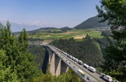 Luftaufnahme einer Brücke der Brennerautobahn in Österreich; eine der beiden Fahrseiten ist vollgestopft mit LKW.
