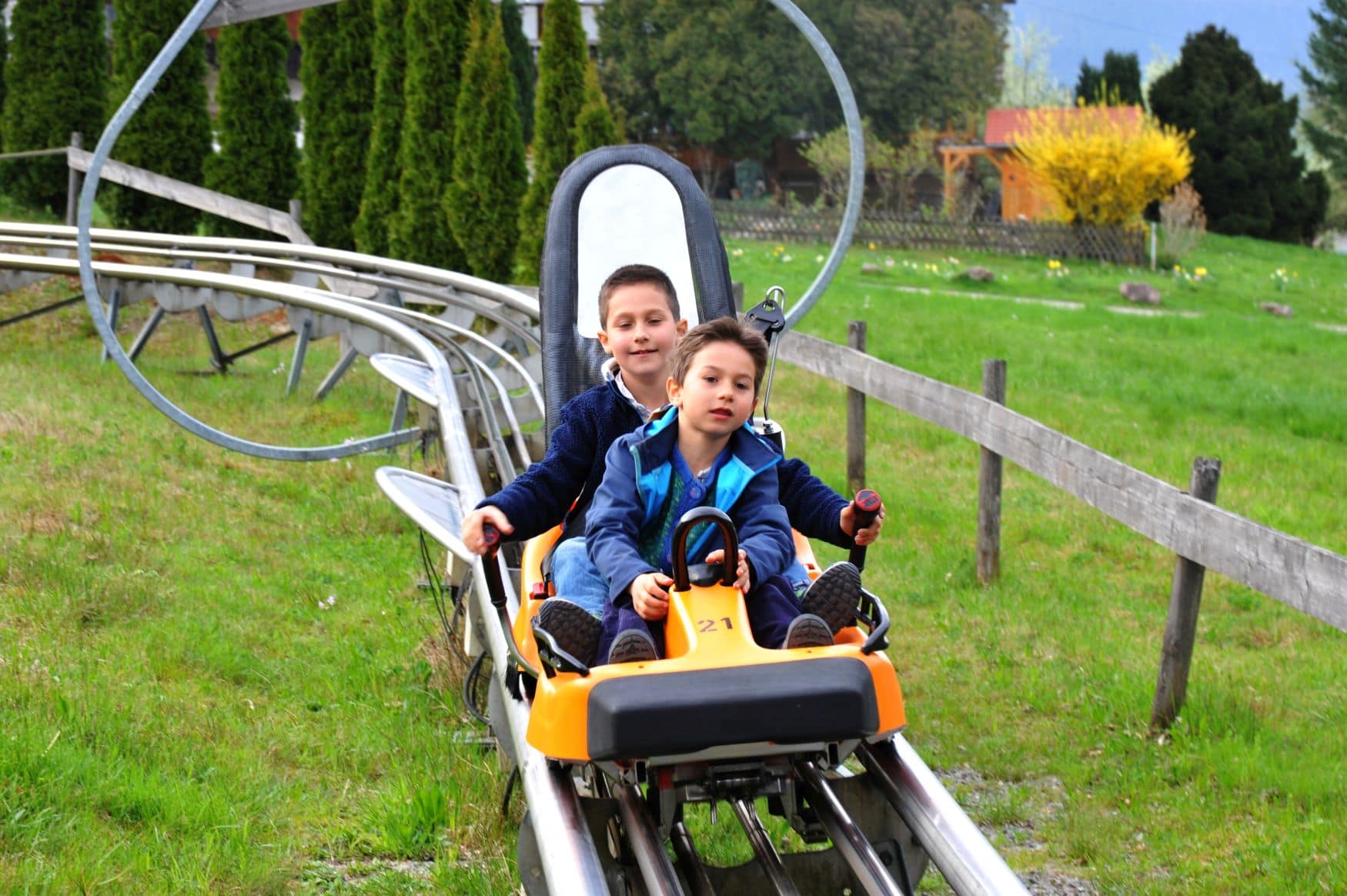 Zwei Jungs fahren auf einer Sommerrodelbahn im Schwarzwald