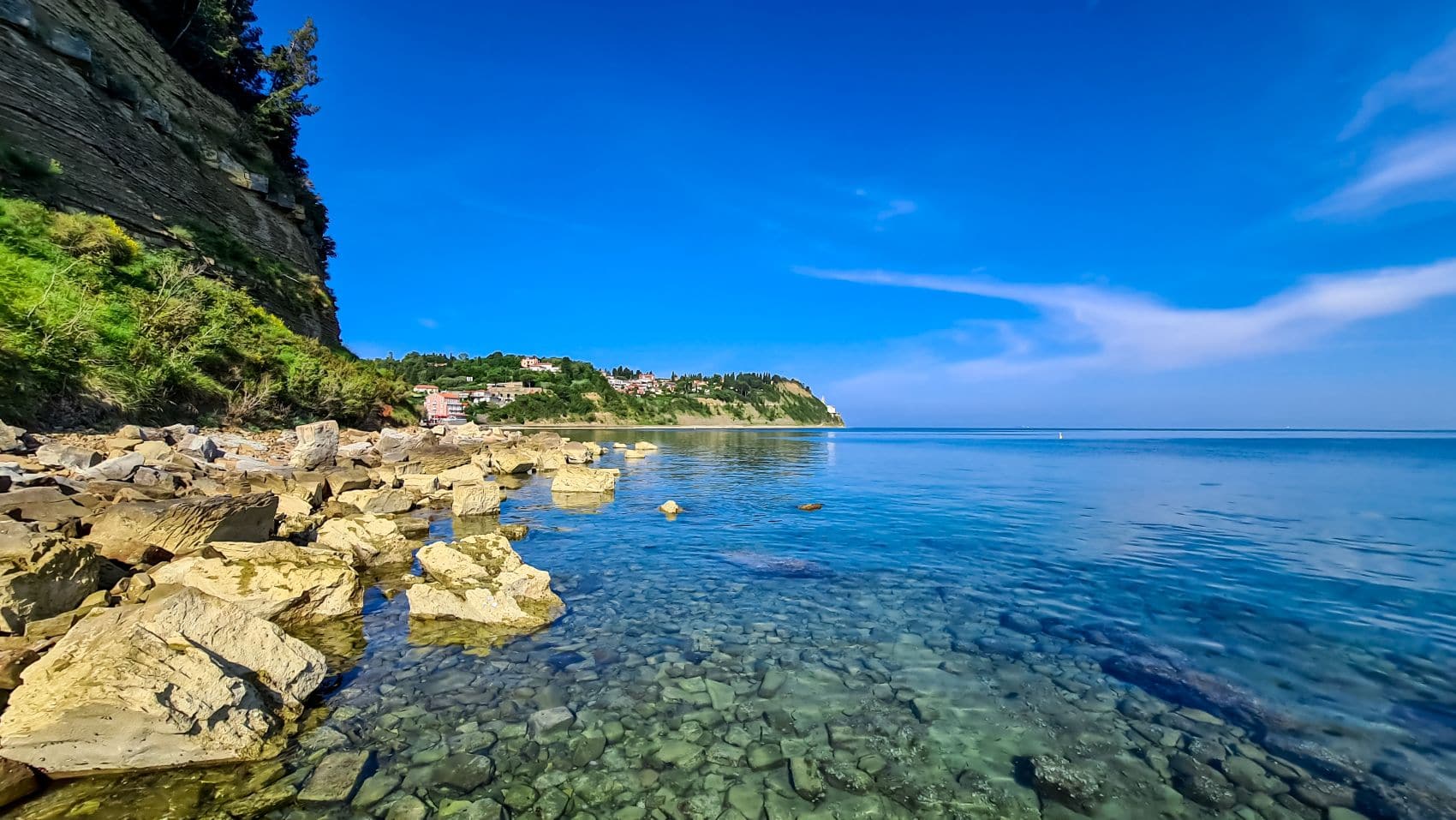 Die Felsenküste von Fiesa an der slowenischen Adriaküste mit glasklarem Wasser und Blick Richtung Piran.