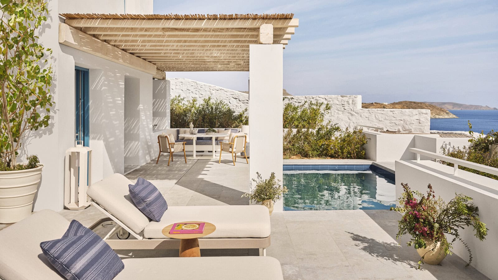 Terrasse einer Suite im Four Seasons Mykonos mit Pergola, Sonnenliegen und Pool am Meer.