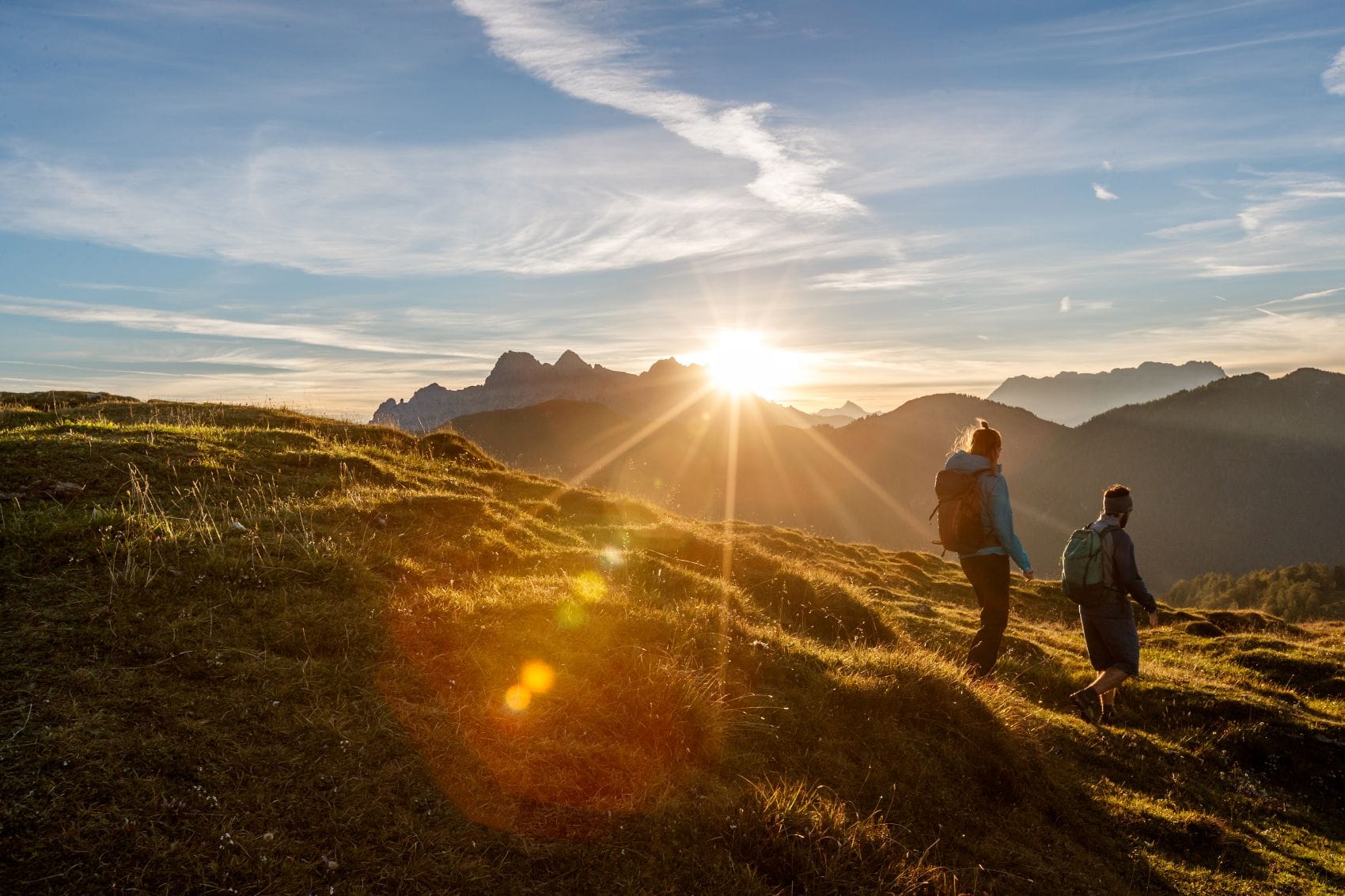 Zwei Wanderer sind auf dem Kat Walk in den Kitzbüheler Alpen bei Sonnenaufgang unterwegs.
