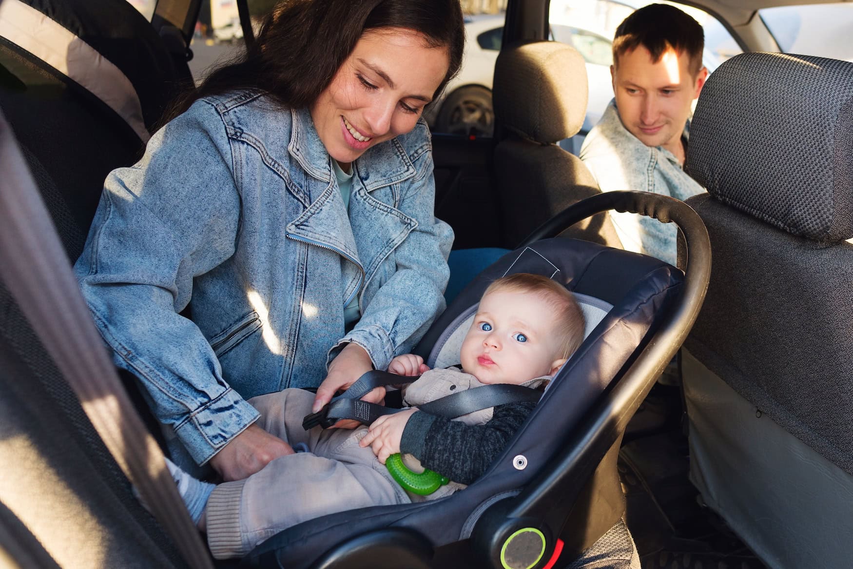 Neugeborenes wird in einer rückwärtsgerichteten Babyschale auf dem Rücksitz angeschnallt