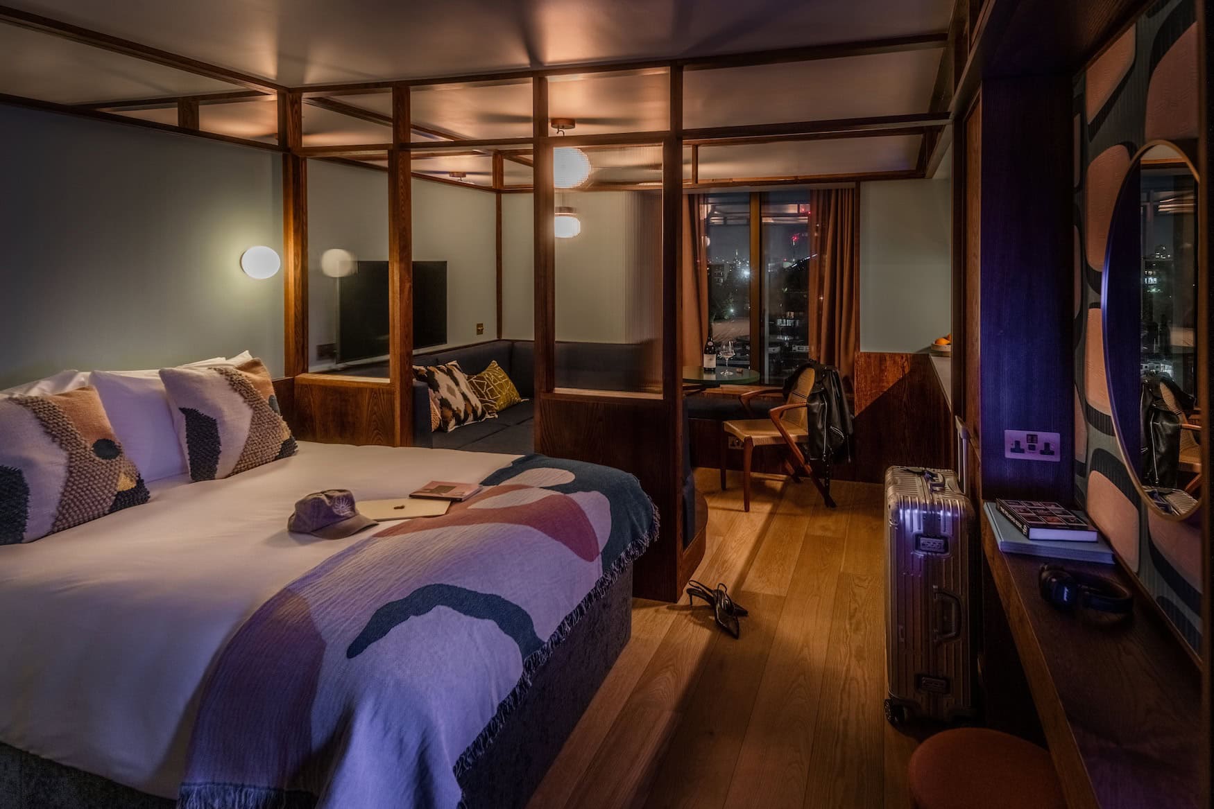 Suite im Locke Canary Wharf mitgerahmtem Bettbereich, Sitzecke und Fensterblick auf London bei Nacht