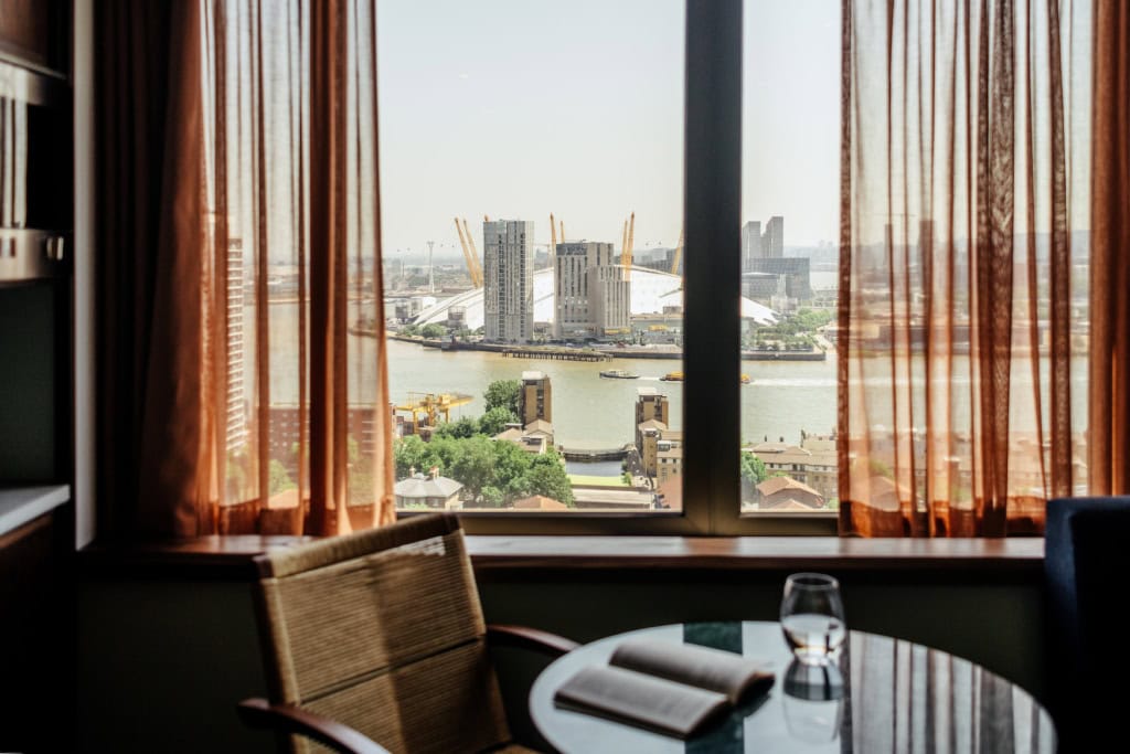Zimmer im Locke Canary Wharf mit Sessel und Blick über die Themse zur O2-Arena