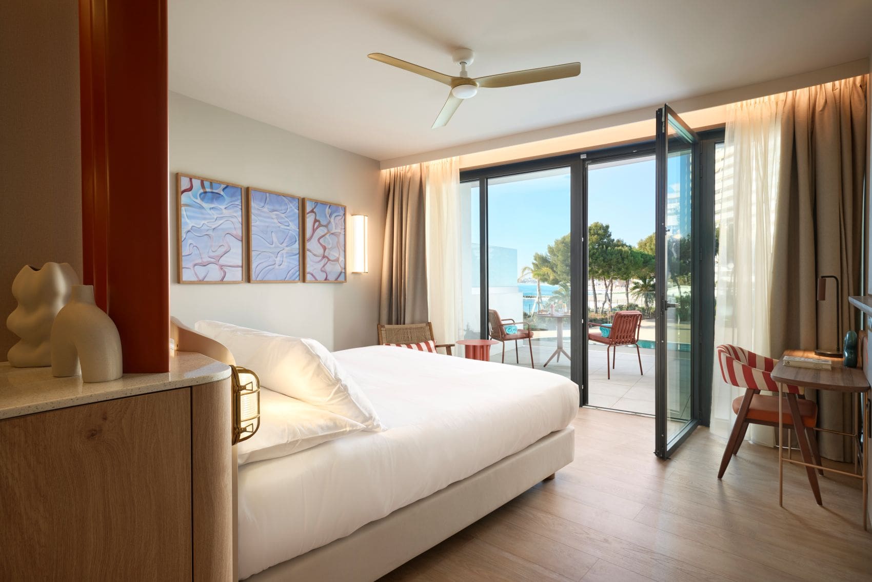 Helles Hotelzimmer im Marina Baie des Anges Hôtel mit Balkon und Blick ins Grüne