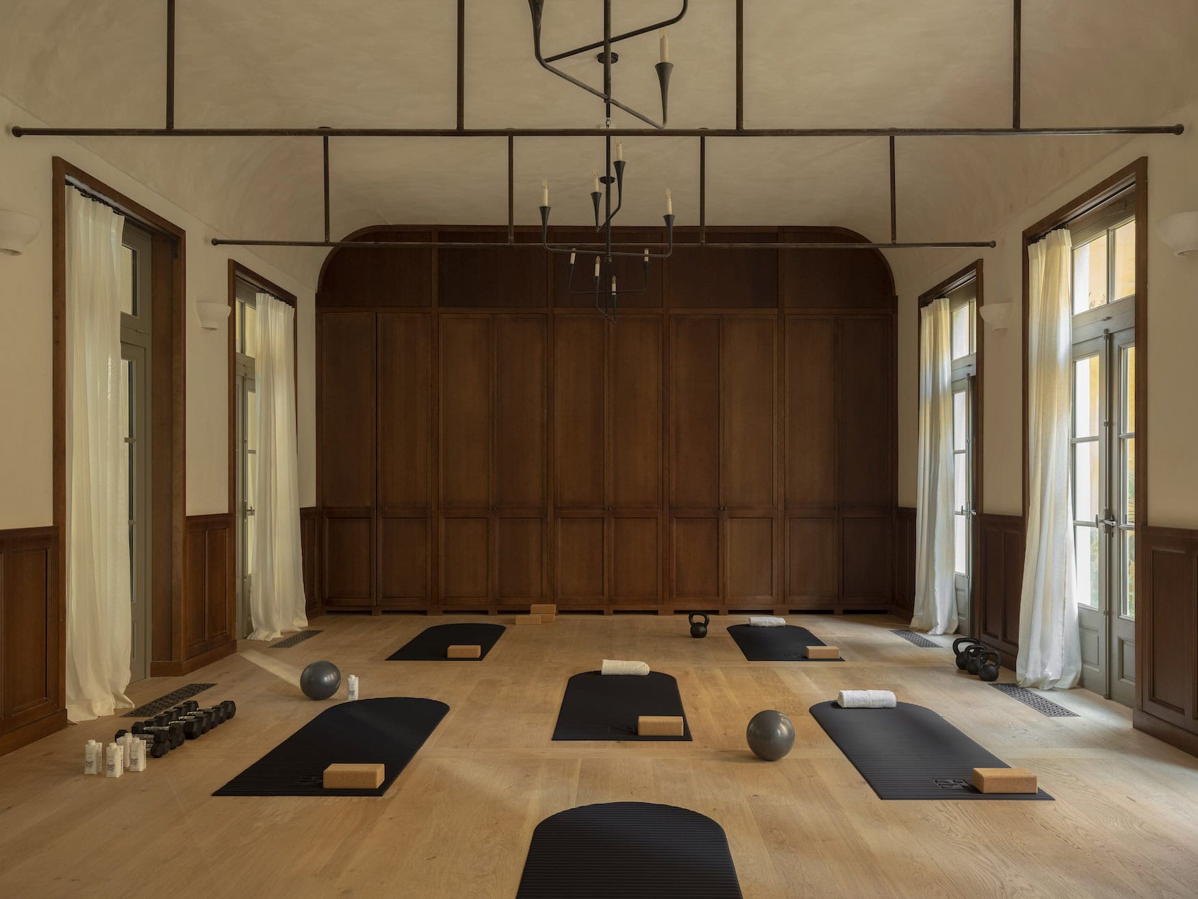 Movement Studio im Hôtel du Couvent in Nizza mit Matten und Kleingeräten vor holzvertäfelter Wand.