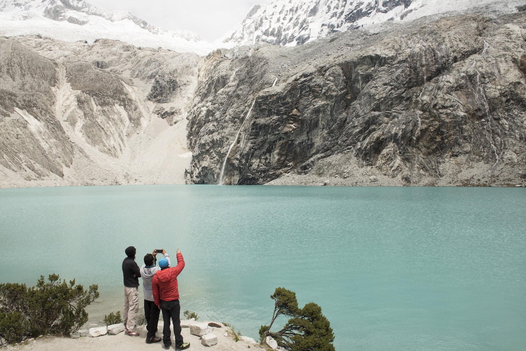 Türkisfarbener Gletschersee Laguna 69 im Nationalpark Huascarán mit Personen am Ufer