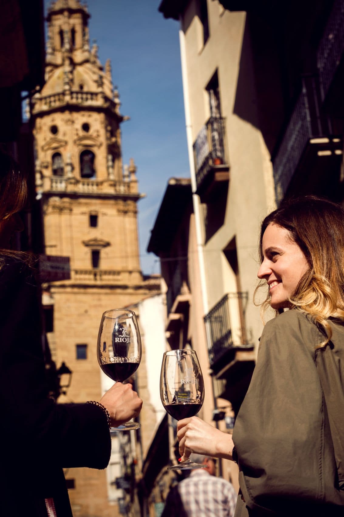 Zwei Frauen genießen ein Glas Rioja-Wein in einer historischen Altstadt der spanischen Weinregion Rioja.