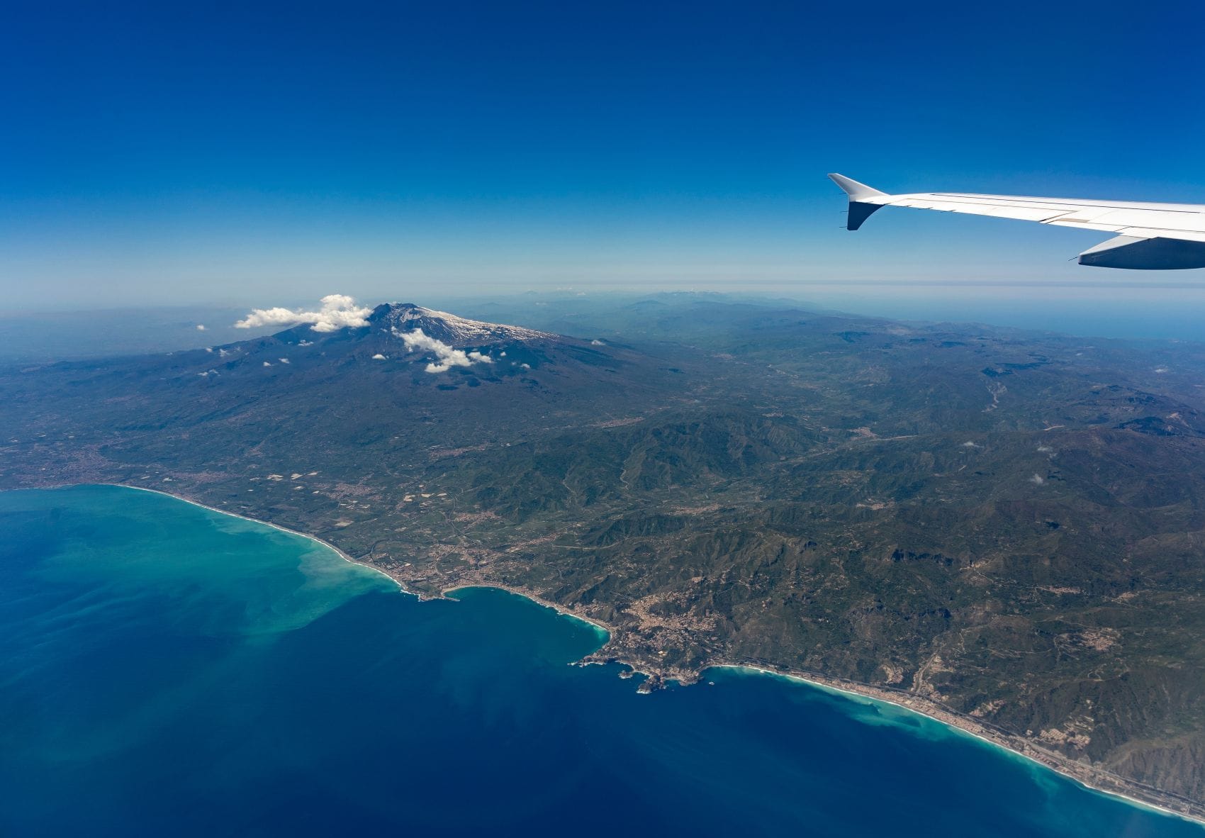 Blick aus einem Flugzeug auf den Ätna und die Ostküste Siziliens.