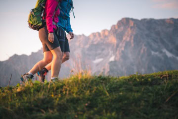 Zwei Wanderer mit Rucksäcken und Wanderschuhen sind im alpinen Gelände am Hochkönig unterwegs.