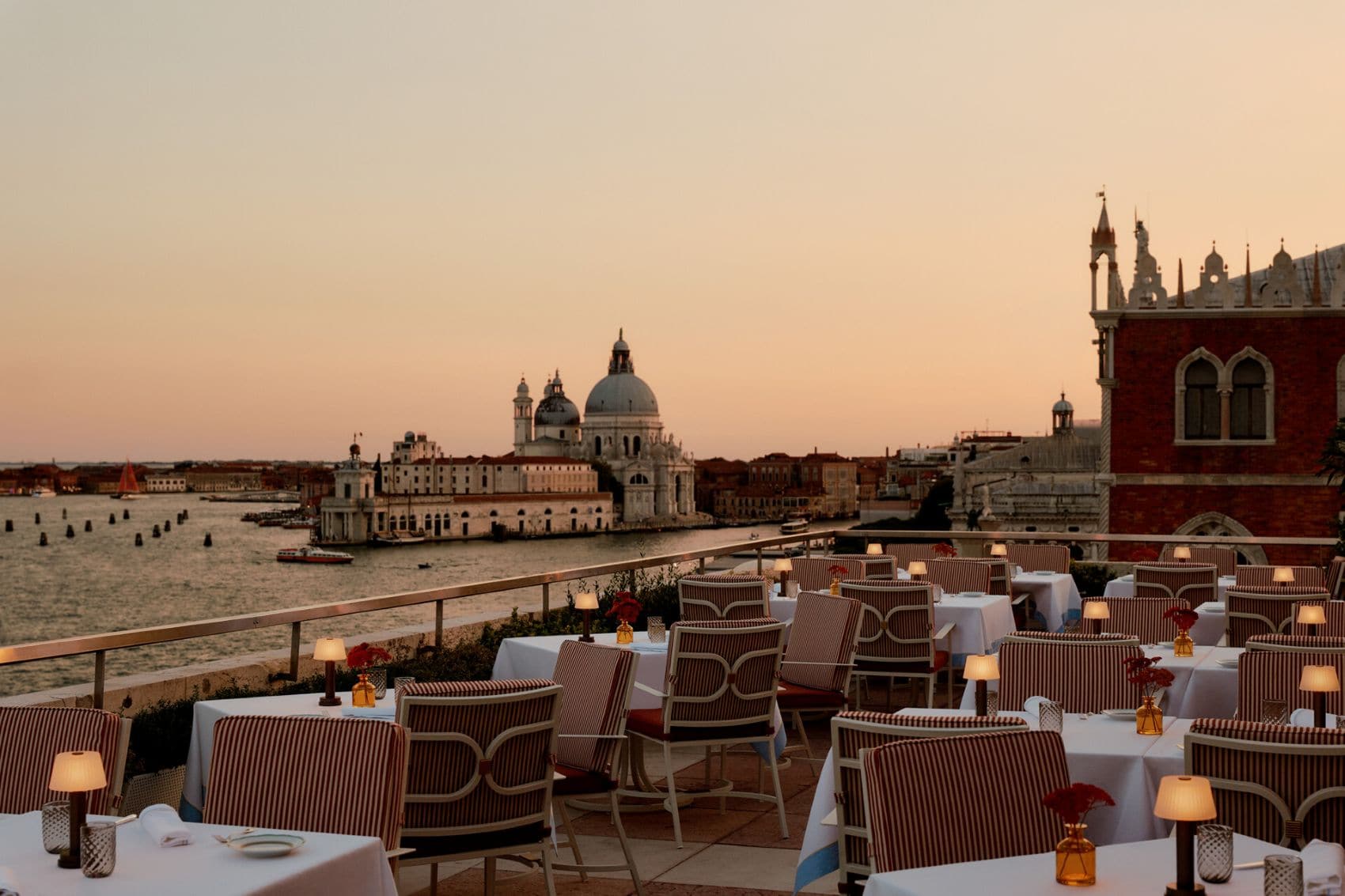 Dachterrasse der Terrazza Danieli bei Sonnenuntergang mit Blick auf die Lagune und die Basilika Santa Maria della Salute in Venedig.