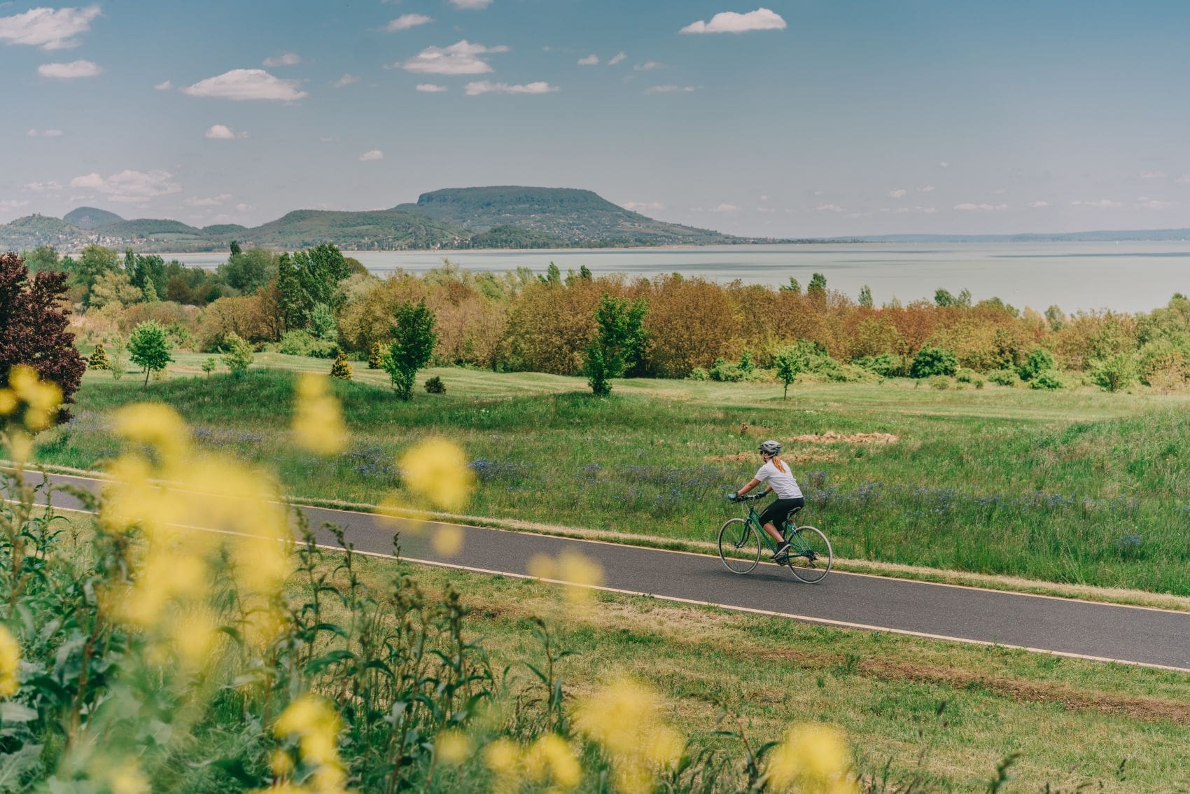 Eine Frau fährt Fahrrad entlang des Balaton. 