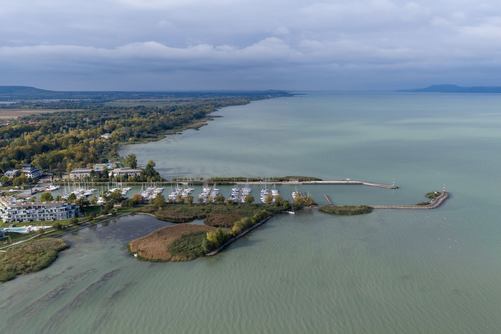 Luftaufnahme eines Yachthafens am Balaton mit flachen Uferbereichen. 