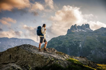 Wanderer mit Rucksack in hochalpiner Berglandschaft