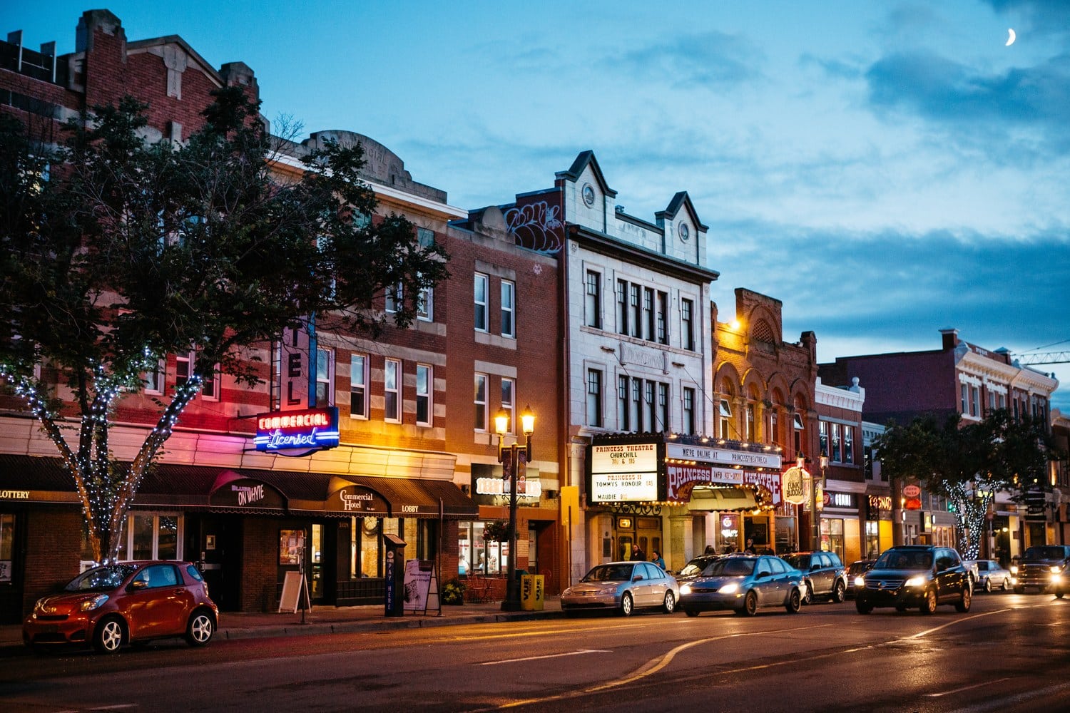 Historische Häuserzeile mit dem Princess Theatre und leuchtenden Neonschildern auf der Whyte Avenue in Edmonton zur blauen Stunde