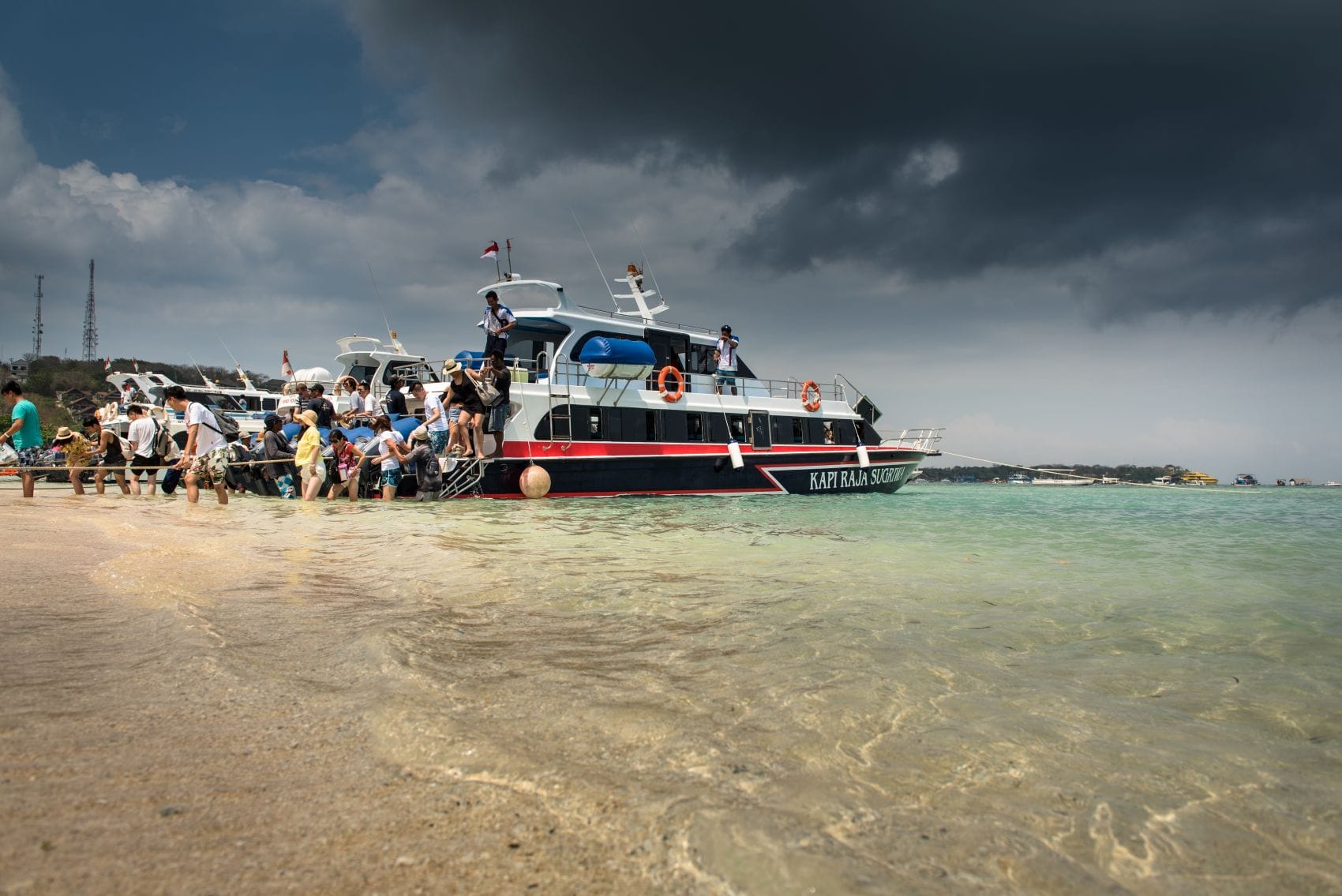 Touristen steigen auf Nusa Lembongan bei Bali in ein Schnellboot