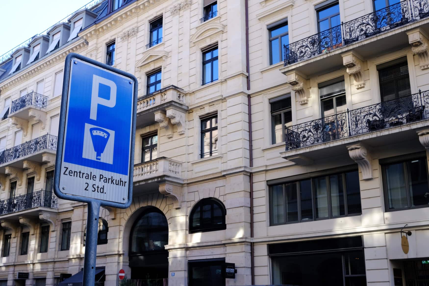 Blaues Schweizer Parkschild mit Aufschrift Zentrale Parkuhr vor einer Altbaufassade in Zürich