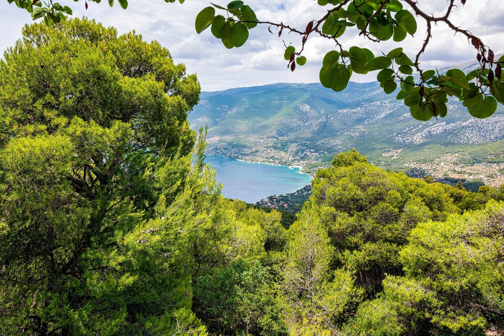 Luftaufnahme von Porto Germeno in Westattika mit Strand, Küste und Bergen im Hintergrund.