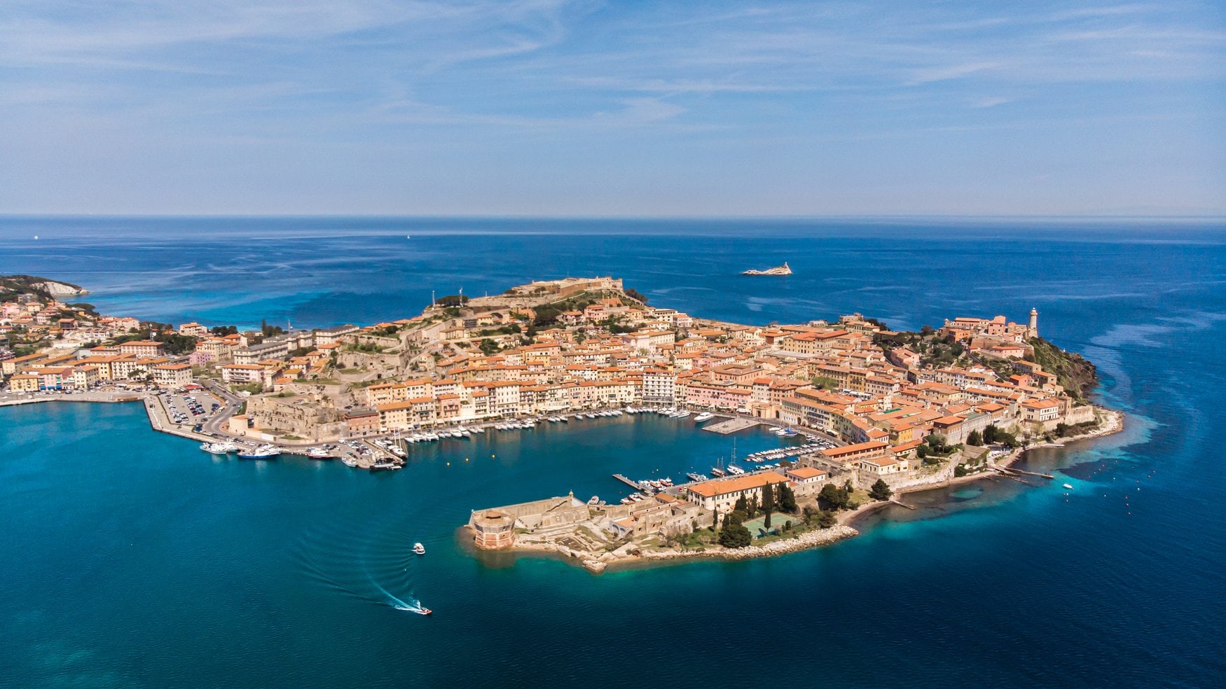 Luftaufnahme der Landzunge von Portoferraio auf Elba mit der Altstadt, dem Hafenbecken und den Festungsanlagen, umgeben vom tiefblauen Tyrrhenischen Meer.