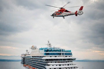 Rettungshubschrauber über Kreuzfahrtschiff