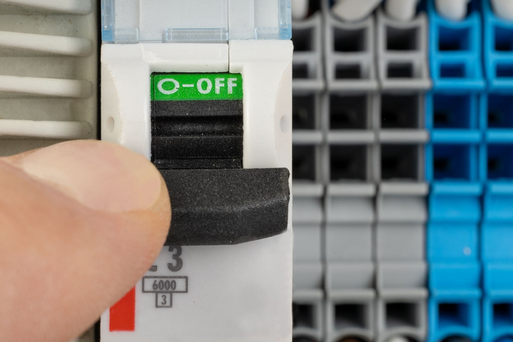 Hand schaltet Sicherung zur Unterbrechung der Stromzufuhr aus