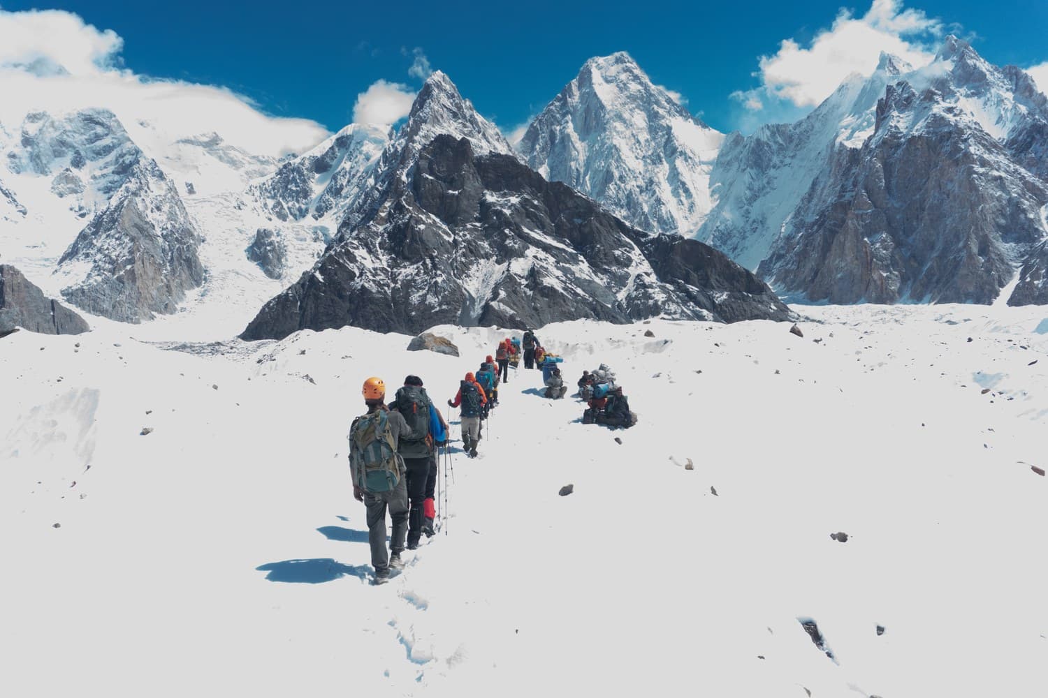 ekkinggruppe geht über den schneebedeckten Baltoro-Gletscher, im Hintergrund die Zacken des Karakorum