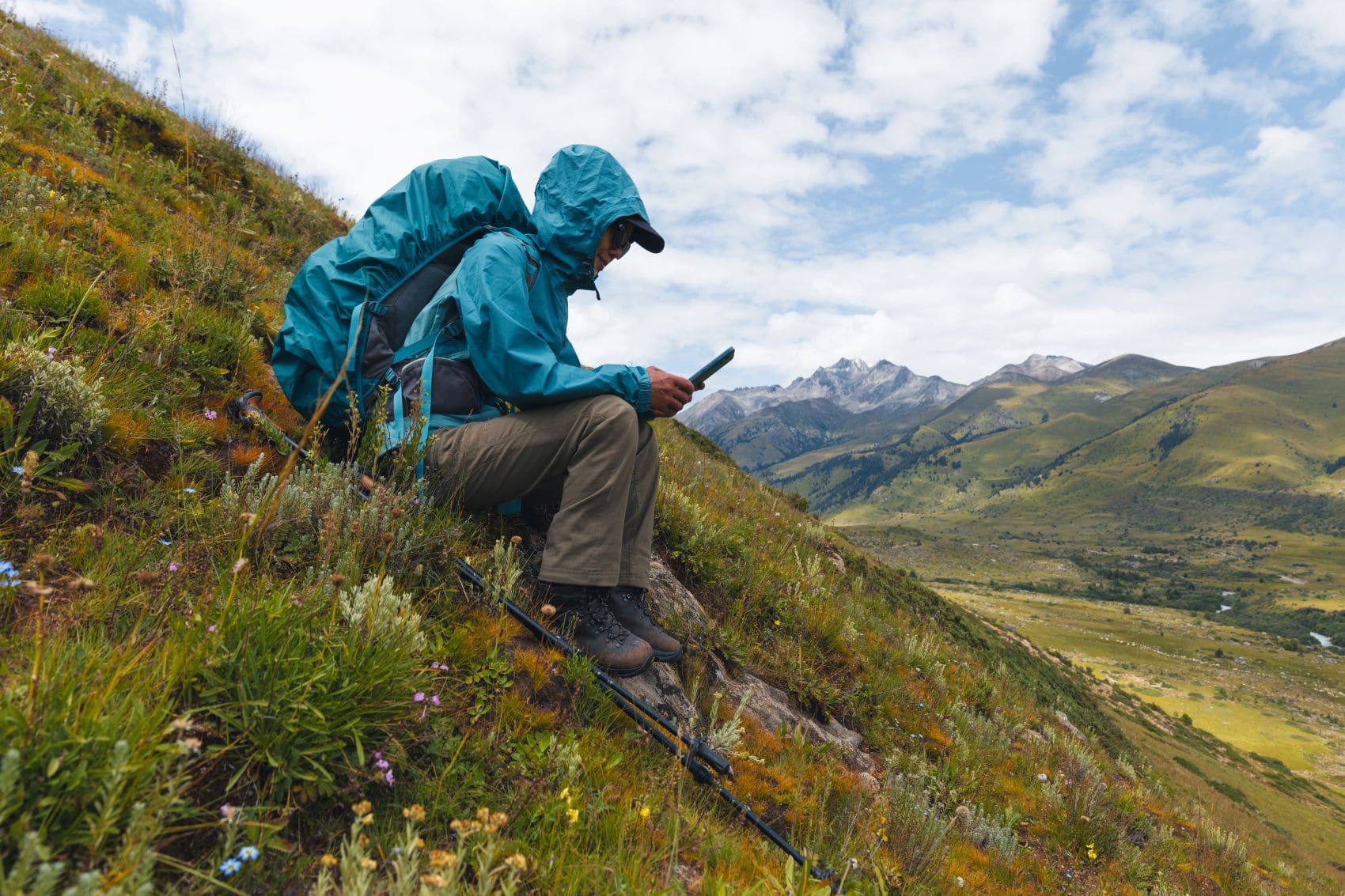 Wanderer prüft auf einer Bergtour die Route auf seinem Smartphone