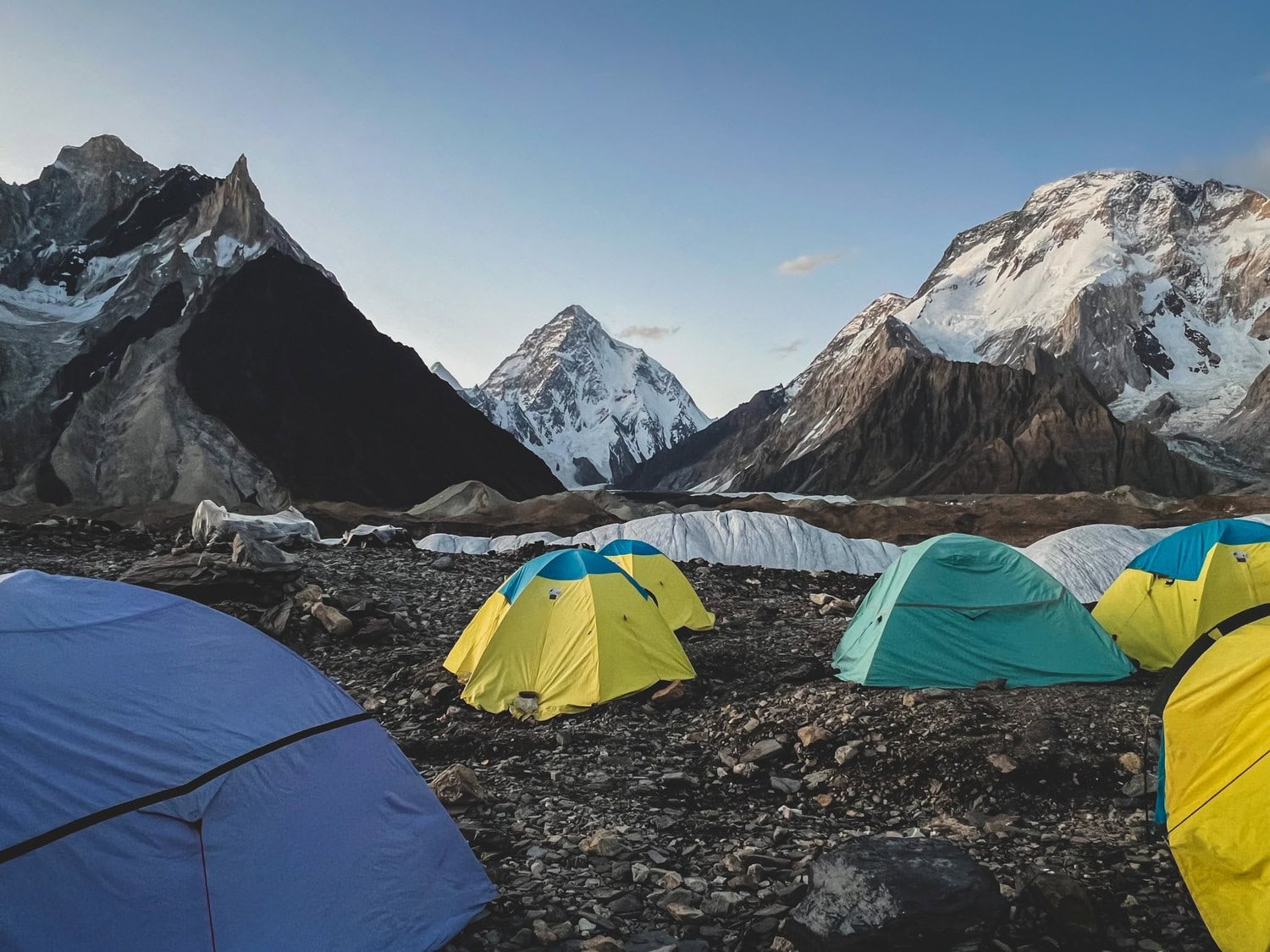 Bunte Zelte auf der Gletschermoräne von Concordia, dahinter die Pyramide des K2