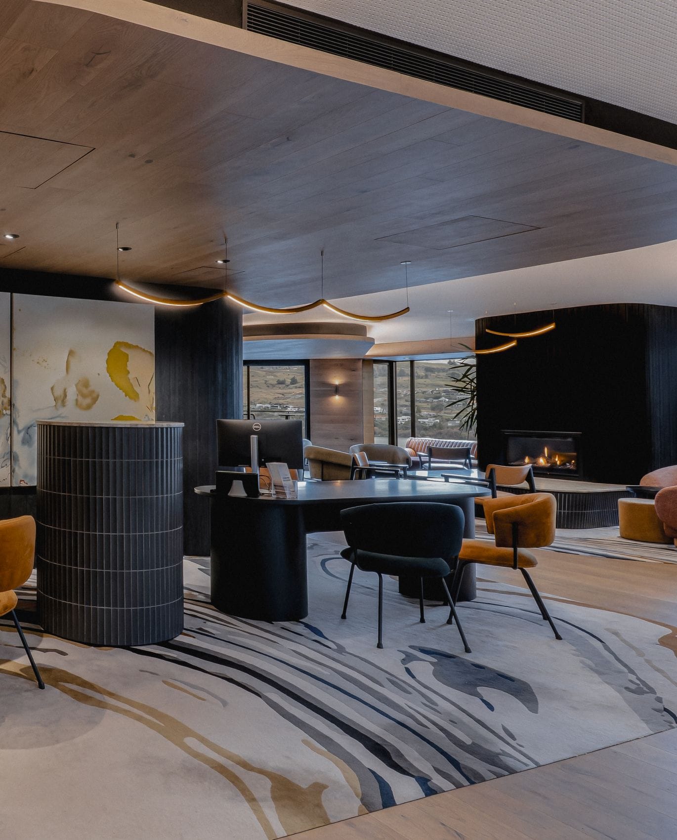 Lobby des Avani Queenstown mit Kamin und moderner Einrichtung