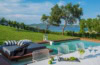 Aussenbereich des Avaton Luxury Beach Resort bei Chalkidiki; im Vordergrund ein weißer Tisch, dahinter eine elegante Liege und ein kleiner Pool.