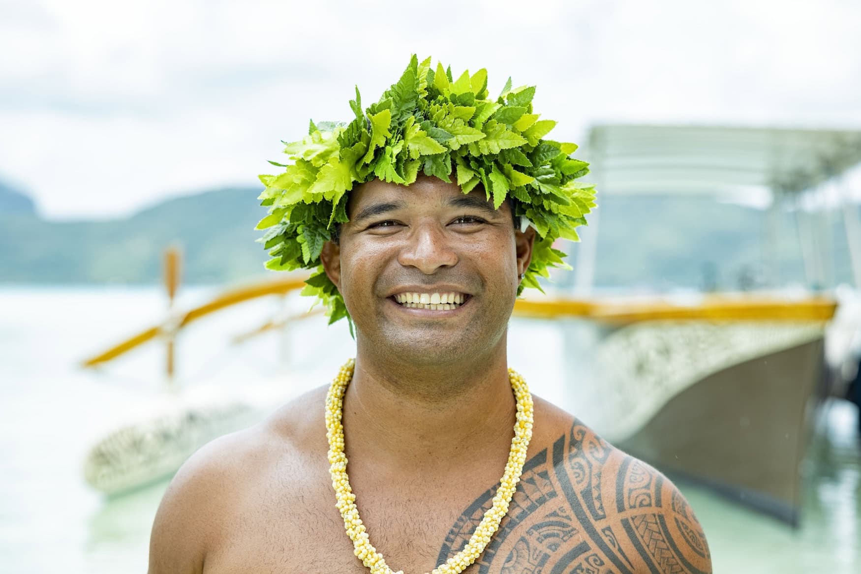 Mann auf Bora Bora mit polynesischer Tätowierung und Blätterkranz für Kultur auf Tahiti.
