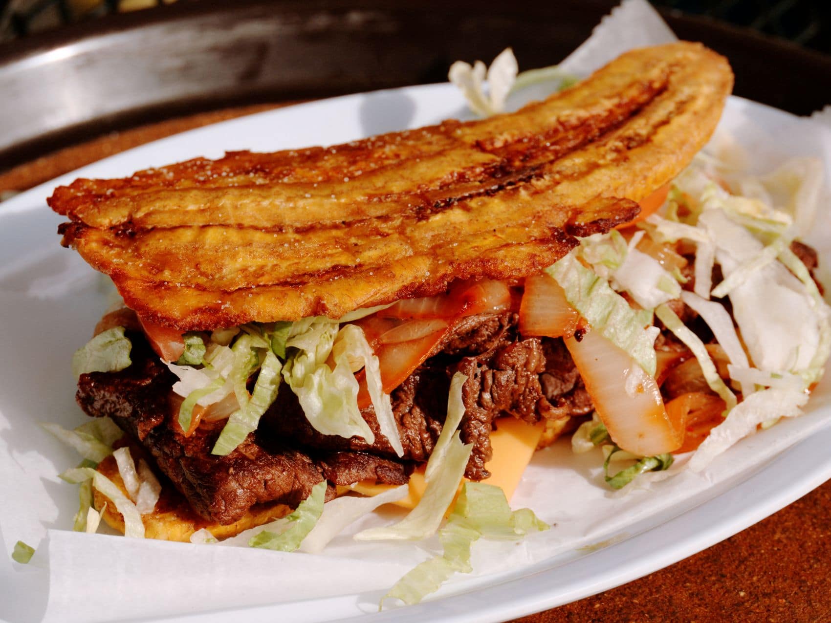 Jibarito mit frittierten Kochbananen, Fleisch, Salat und Tomaten in Chicago
