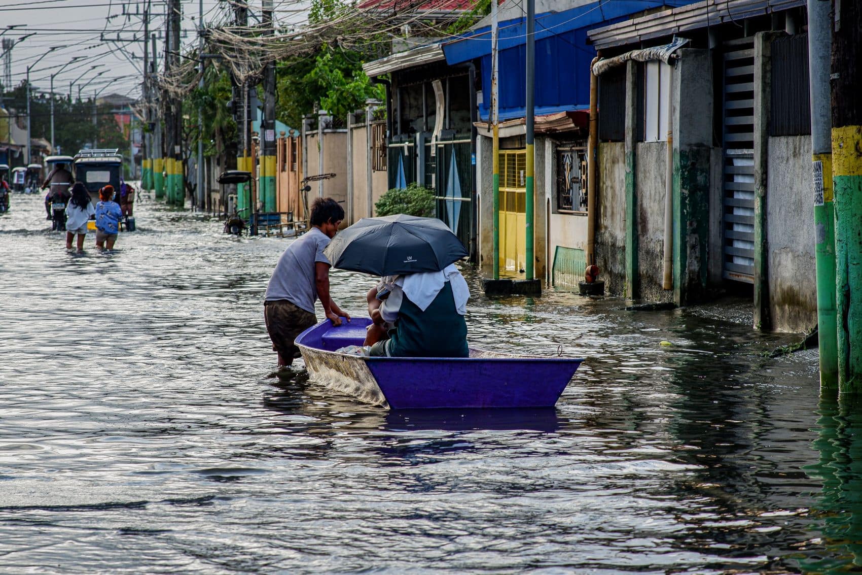 Menschen bewegen sich nach Taifun Fung-wong durch eine überflutete Straße in Bulacan auf den Philippinen.