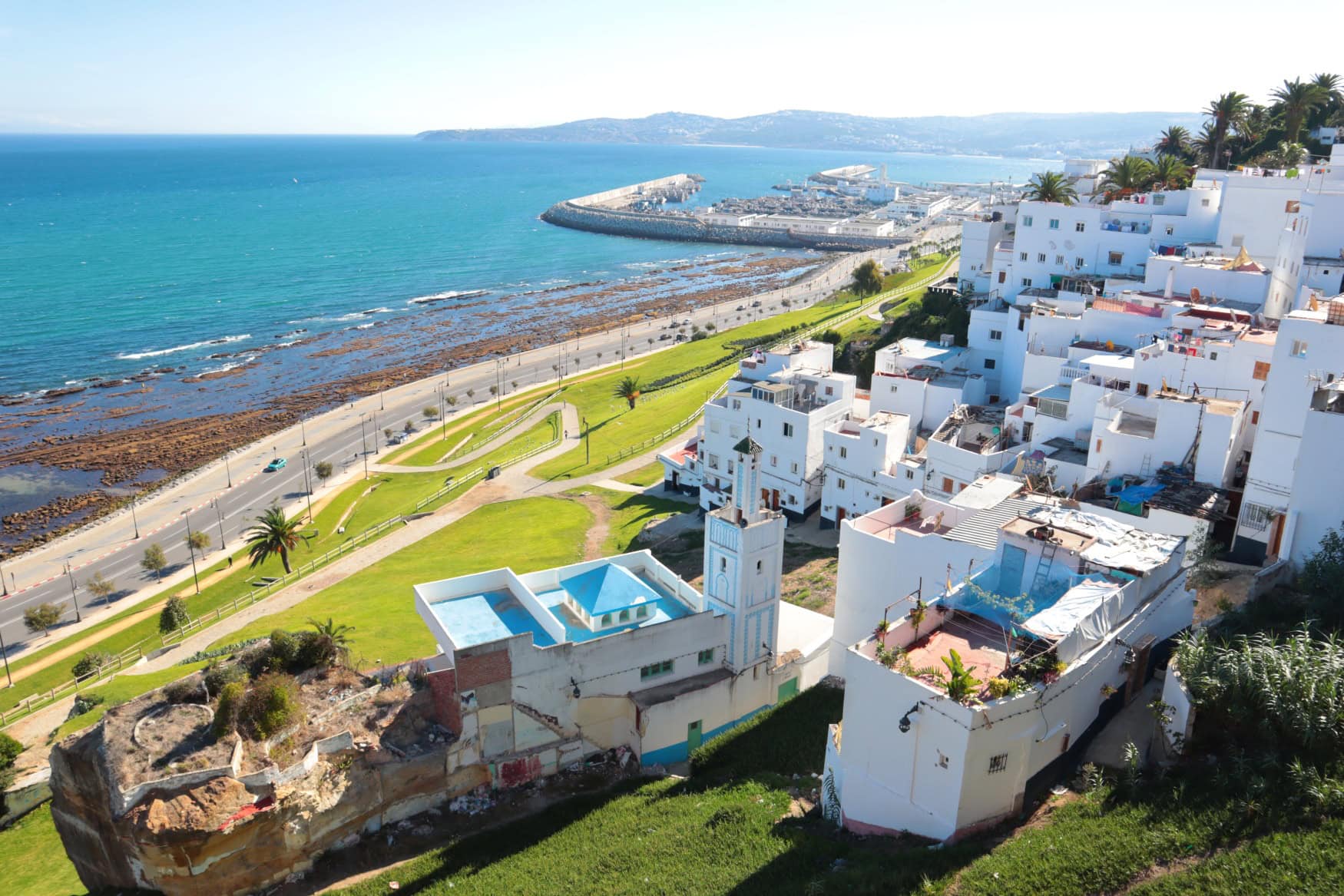 Die weiß getünchte Altstadt von Tanger in Marokko, von einer Anhöhe aufgenommen, im Hintergrund das Meer.