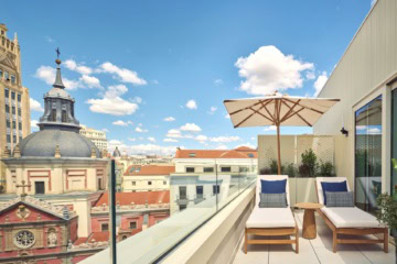 Private Terrasse einer Suite im Nobu Hotel Madrid mit Sonnenliegen und Blick über die Dächer der spanischen Hauptstadt.