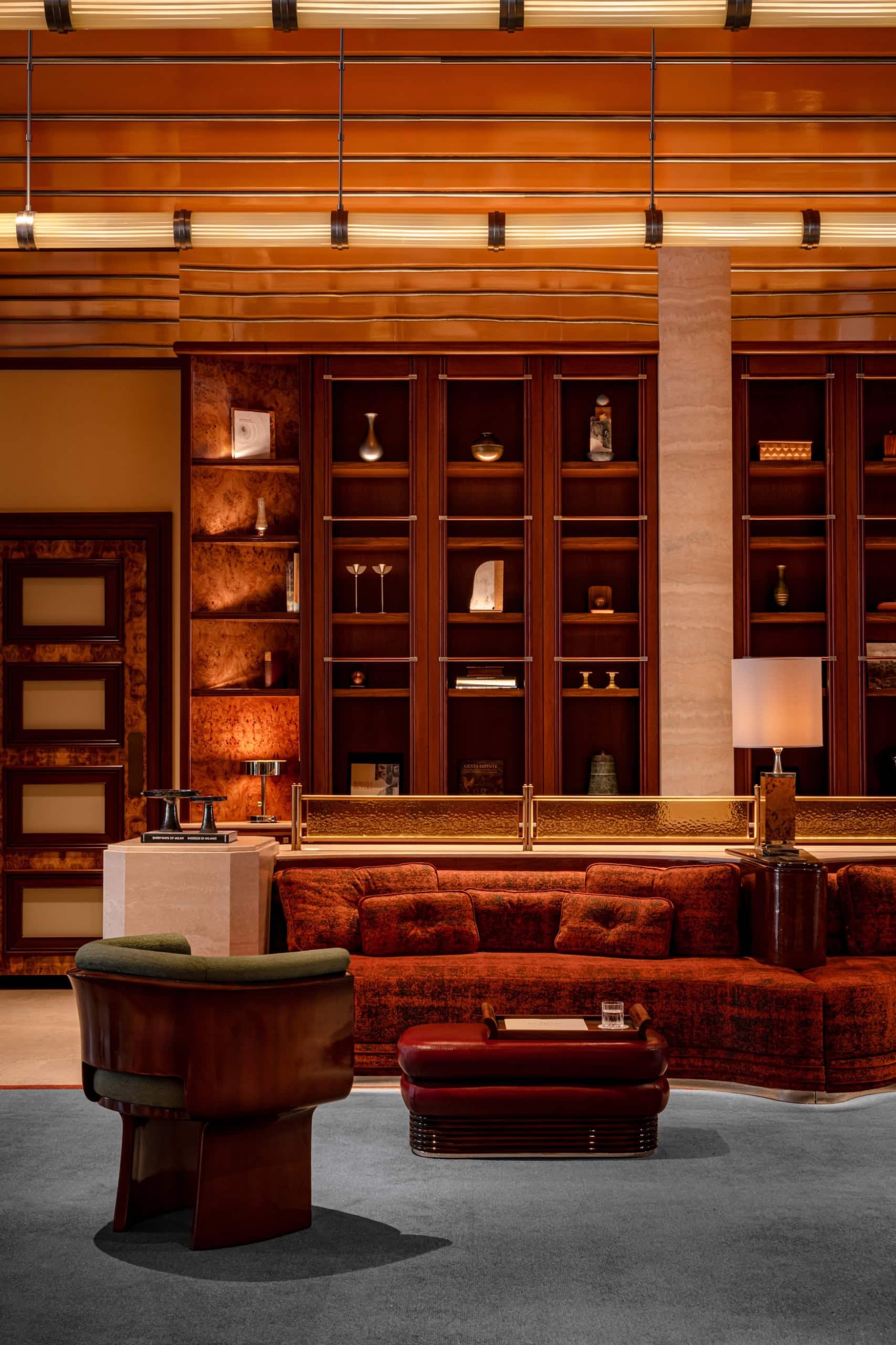 Lounge im La Dolce Vita Orient Express mit Nussbaumregalen und rotem Samtsofa im Stil der 60er Jahre