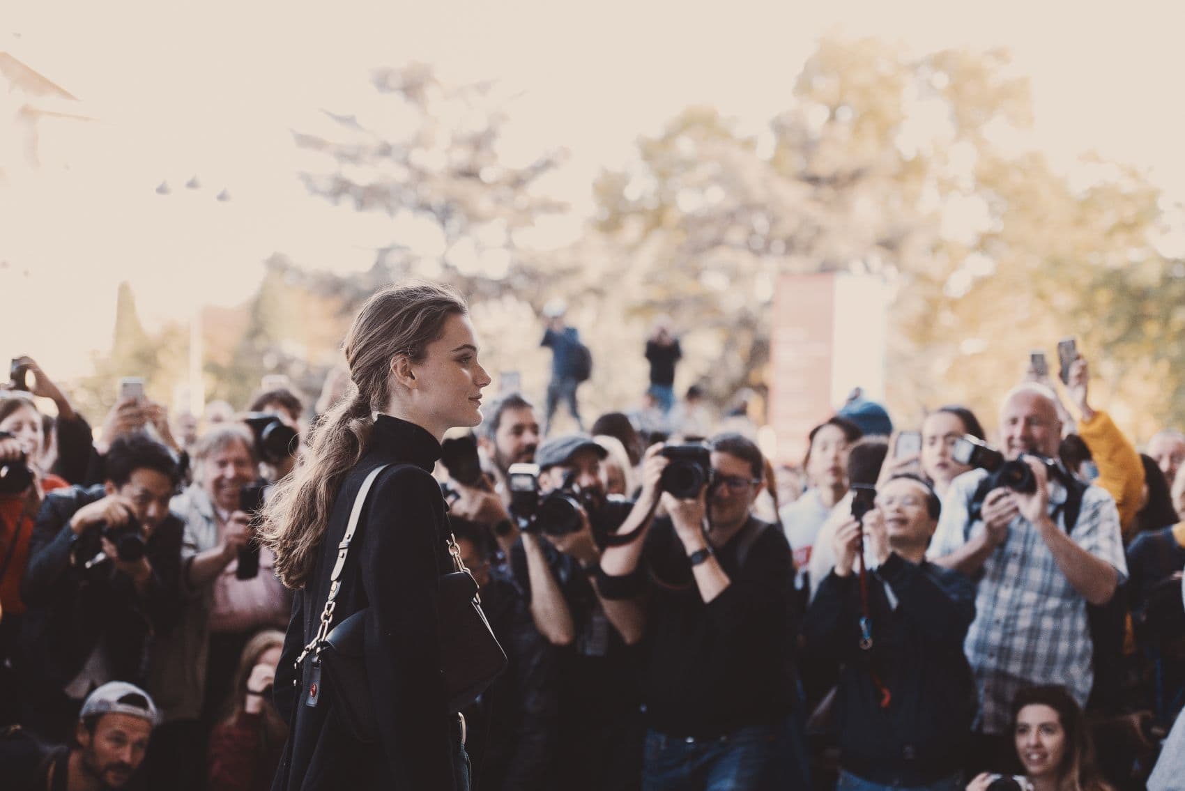 Fotografen fotografieren eine Frau während der Paris Fashion Week
