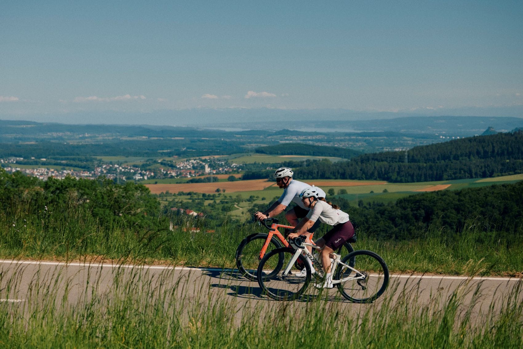 Zwei Radfahrer fahren durch die hügelige Landschaft des Donauberglands bei Geisingen.